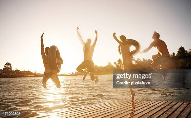 those who don't jump will never fly - group-of-friends-jumping-off-dock-into-lake stock pictures, royalty-free photos & images