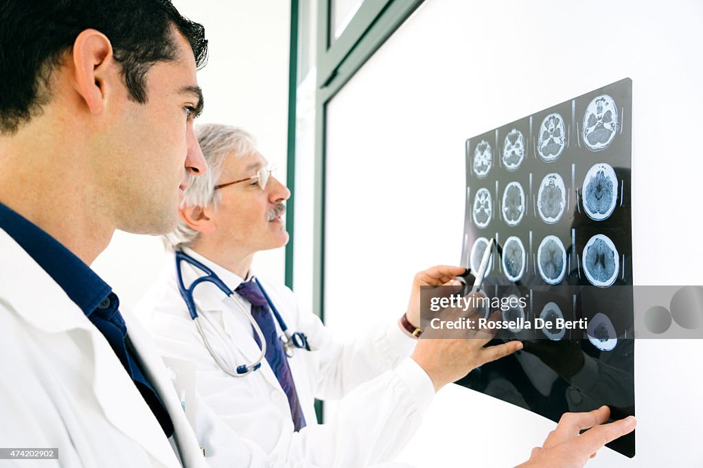 Doctors Consult Over An MRI Scan Of The Brain
