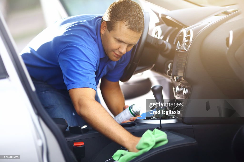 Man cleaning upholstery of his vehicle.