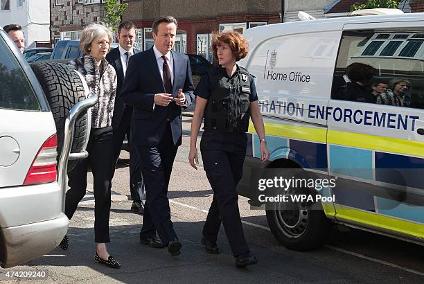 Home Secretary Theresa May and Prime Minister David Cameron talk to Immigration Enforcement officers after the officers raided residential properties...