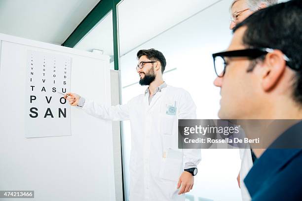 opticians making eye test to a patient - eye chart stock pictures, royalty-free photos & images