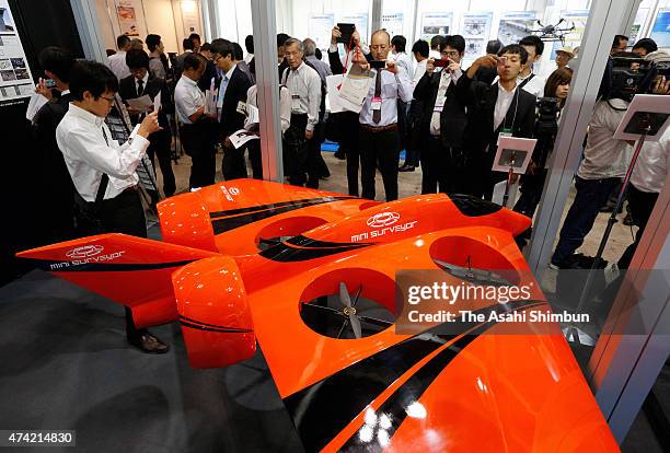 Visitors check drones during the International Drone Expo 2015 at Makuhari Messe on May 20, 2015 in Chiba, Japan. Fifty or so companies from Japan,...