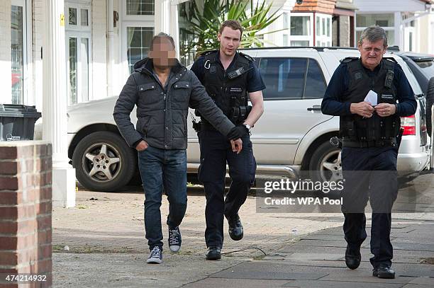 Sri Lankan man is led away by Immigration Enforcement officers after a raid on a residential property looking for illegal immigrants in Southall, on...