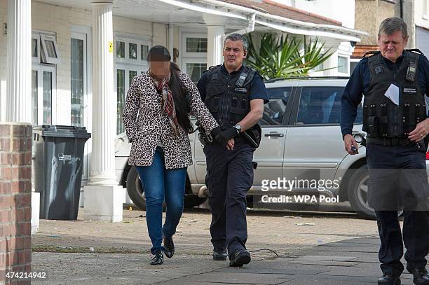 Sri Lankan woman is led away by Immigration Enforcement officers after a raid on a residential property looking for illegal immigrants in Southall,...