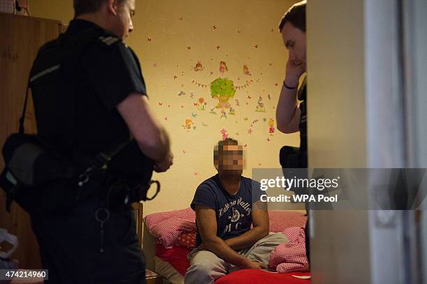 Sri Lankan man is interviewed by Immigration Enforcement officers after a raid on a residential property looking for illegal immigrants in Southall,...