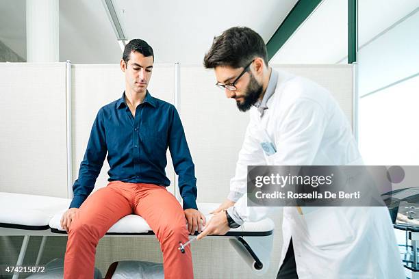 physical therapist examining patient's reflexes with reflex hammer - reflex hammer stock pictures, royalty-free photos & images