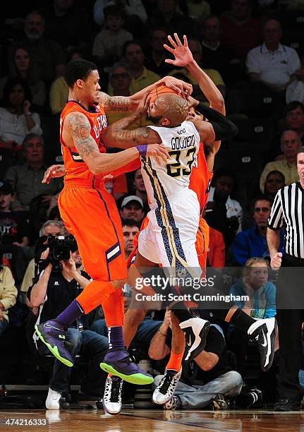 Trae Golden of the Georgia Tech Yellow Jackets drives against K. J. McDaniels and Jason Blossomgame of the Clemson Tigers at McCamish Pavilion on...