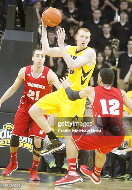Forward Aaron White of the Iowa Hawkeyes grabs a rebound during the first half between guards John Gasser and Traevon Jackson of the Wisconsin...
