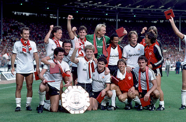 Manchester United celebrate with the FA Charity Shield after their 2-0 victory over Liverpool at Wembley Stadium, August 20th 1983. Back row : Ray...