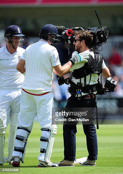 Joe Root of England helps a steadicam operator to his feet after the pair collided during day one of the 1st Investec Test match between England and...