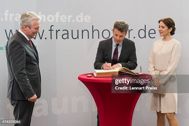 Crown Prince Frederik and Crown Princess Mary Of Denmark sign the Golden Book of Fraunhofer Institut next to Alexander Verl, Executive Vice President...
