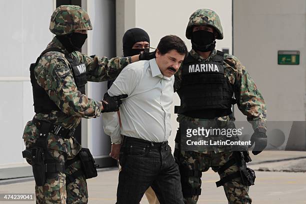 Joaquin "El Chapo" Guzman is escorted to a helicopter in handcuffs by Mexican navy marines at a navy hanger. Guzman leader of Mexico's Sinaloa drug...