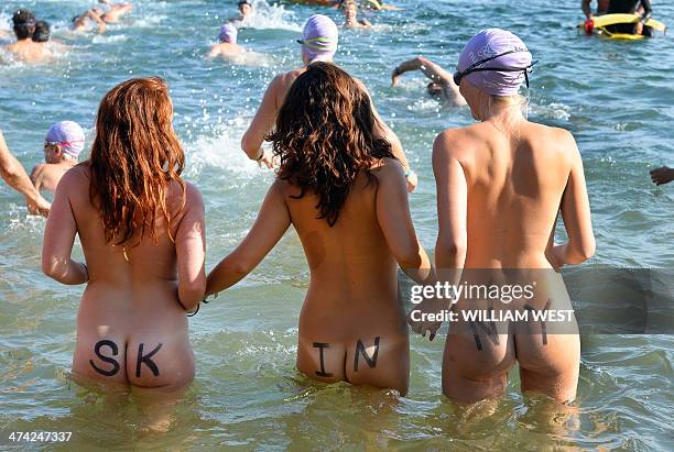 Three competitors with 'Skinny' written on the bottoms enter the water at the start the second annual Sydney Skinny where they take part in an...