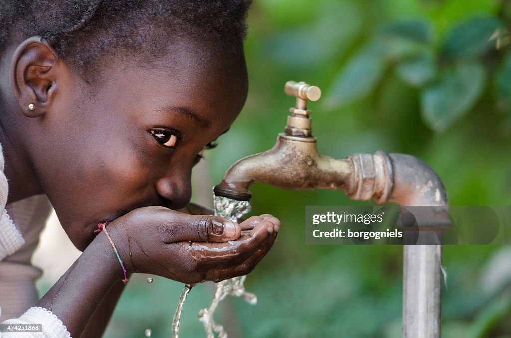 Social Issues: African Black Child Drinking Fresh Water From Tap