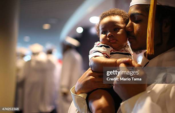 McDonogh Senior High School graduate Damian Keelen holds his son Damian Jr. At his commencement at the Ernest N. Morial Convention Center on May 14,...