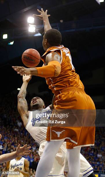 Naadir Tharpe of the Kansas Jayhawks shoots around Jonathan Holmes of the Texas Longhorns in the first half at Allen Fieldhouse on February 22, 2014...