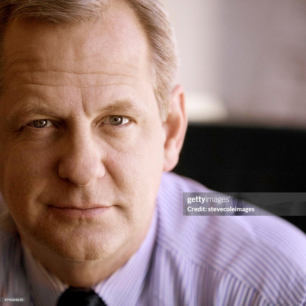 Portrait of senior businessman looking at camera.