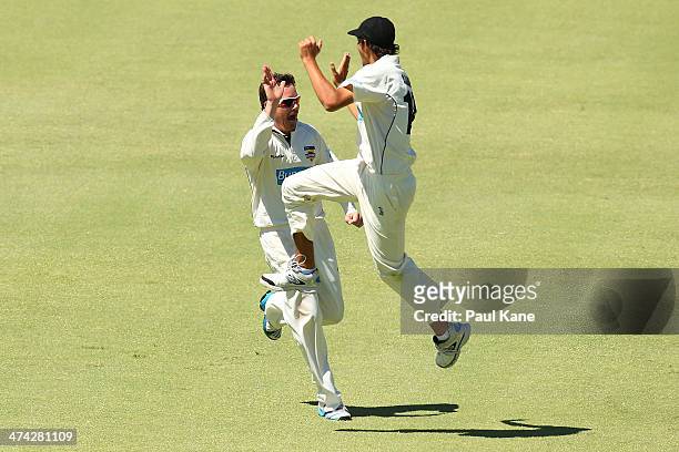 Marcus North of the Warriors celebrates with Ashton Agar after dismissing Peter Nevill of the Blues during day four of the Sheffield Shield match...
