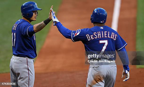 Yu Darvish of the Texas Rangers celebrates with Delino DeShields in the first inning against the Boston Red Sox after both scored at Fenway Park on...