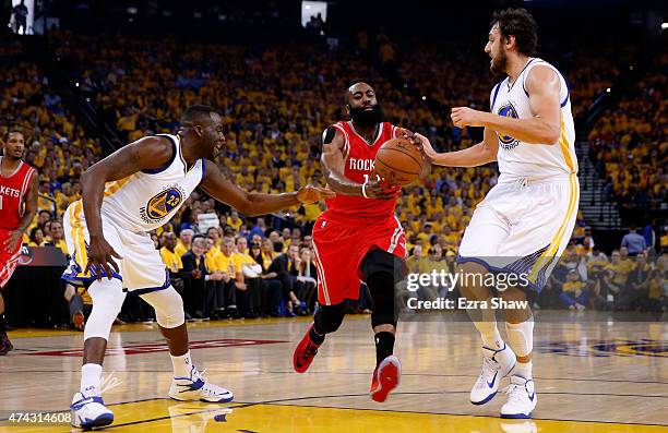 James Harden of the Houston Rockets drives to the basket between Draymond Green and Andrew Bogut of the Golden State Warriors in the first quarter...