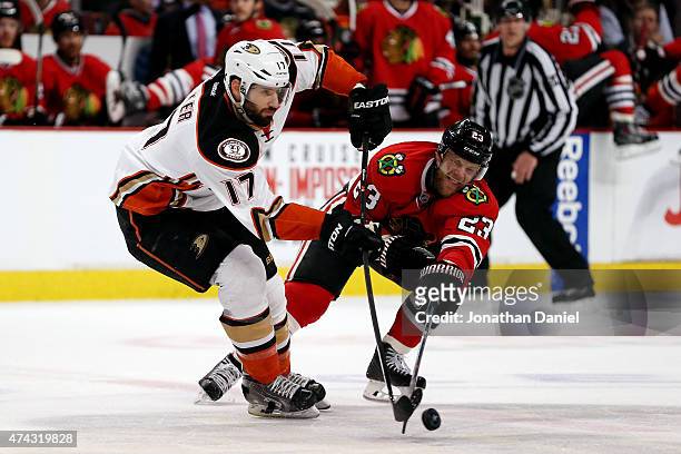 Ryan Kesler of the Anaheim Ducks passes the puck as Kris Versteeg of the Chicago Blackhawks defends in Game Three of the Western Conference Finals...