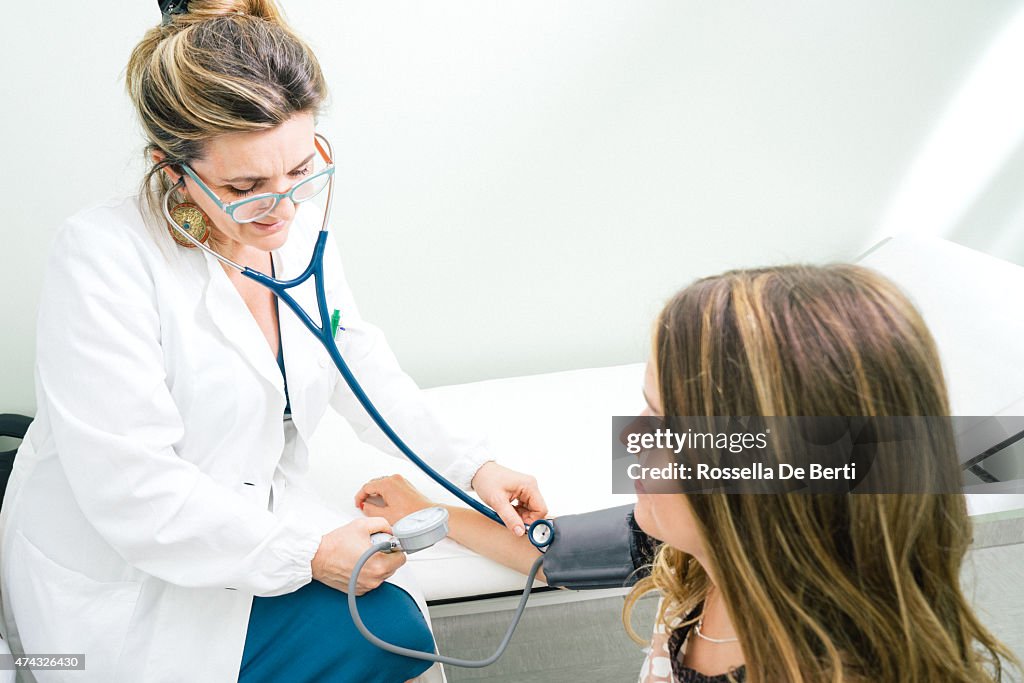 Feminino maduro médico medir a pressão arterial