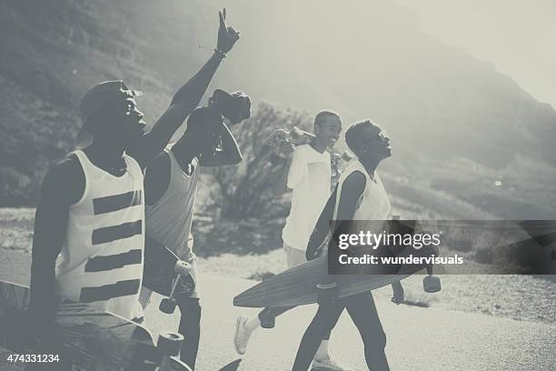 vintage shot of cool teen skateboarders walking together - vintage surf stock pictures, royalty-free photos & images