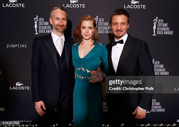 Costume designer Michael Wilkinson, honoree Amy Adams and actor Jeremy Renner pose with the Lacoste Spotlight Award during the 16th Costume Designers...