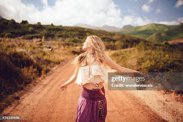 boho girl on a country dirt road being joyful - boho stock pictures, royalty-free photos & images