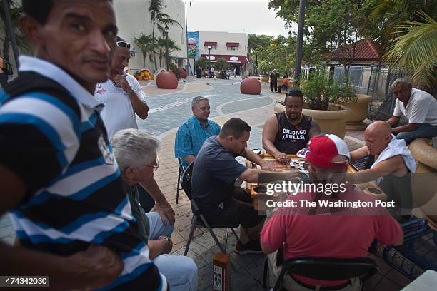 After closing time, men play dominos outside Domino Park on SW 8th St in the Little Havana area of Miami on May 14, 2015.