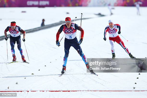 Maxim Vylegzhanin of Russia, Alexander Legkov of Russia and Martin Johnsrud Sundby of Norway approach the finish in the Men's 50 km Mass Start Free...
