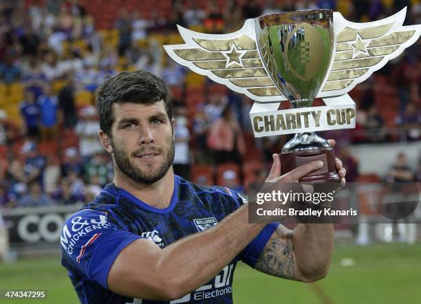 Michael Ennis of the Bulldogs holds up the inaugural Charity Cup winners trophy during the NRL trial match between the Melbourne Storm and the...