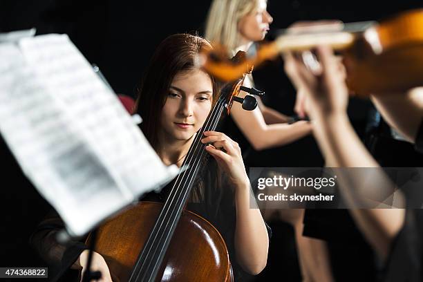 joven mujer tocando violonchelo. - musical instrument string fotografías e imágenes de stock