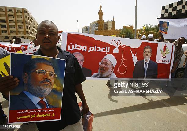 Sudanese Islamists hold posters bearing portraits of Egypt's ousted president Mohamed Morsi , Egyptian Muslim Brotherhood leader Mohamed Badie and...