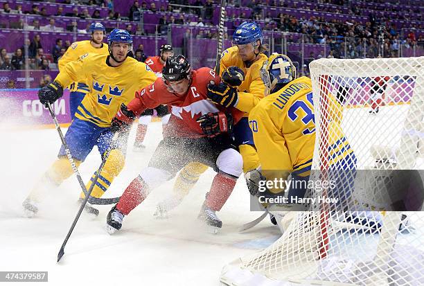 Jimmie Ericsson and Erik Karlsson of Sweden challenge Sidney Crosby of Canada for the puck during the Men's Ice Hockey Gold Medal match on Day 16 of...