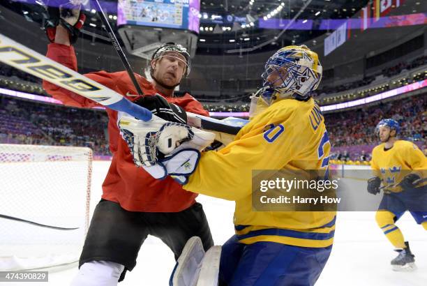 Jeff Carter of Canada collides with Henrik Lundqvist of Sweden during the Men's Ice Hockey Gold Medal match on Day 16 of the 2014 Sochi Winter...