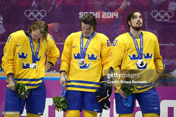 The dejected Carl Hagelin, Erik Karlsson and Marcus Johansson of Sweden look on after receiving the silver medals won during the Men's Ice Hockey...