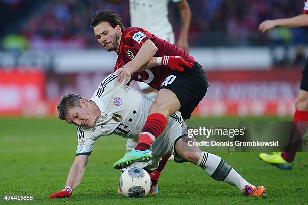 Bastian Schweinsteiger of FC Bayern Muenchen is challenged by Szabolcs Huszti of Hannover 96 during the Bundesliga match between Hannover 96 and FC...