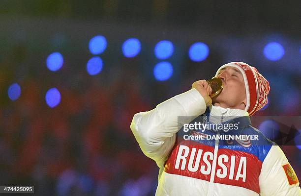 Russia's gold medalist Alexander Legkov kisses his medal on the podium during the Men's Cross-Country Skiing 50km Mass Start Free Victory Ceremony at...