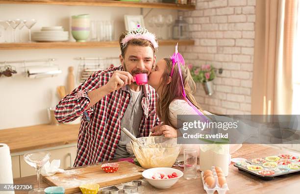 father and daughter baking and having tea party in kitchen. - elf toy stockfoto's en -beelden