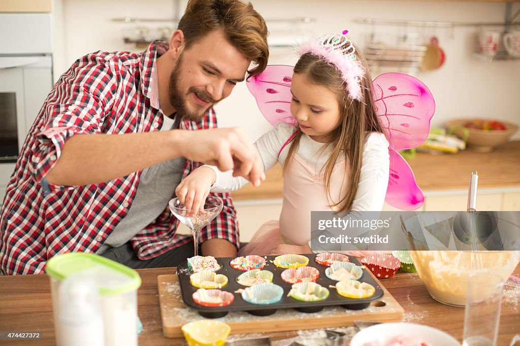 Father and daughter baking in kitchen.