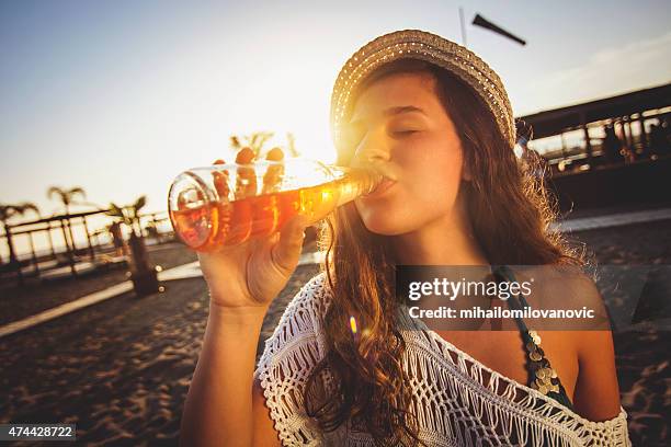 garota na praia a beber cerveja - sedento - fotografias e filmes do acervo