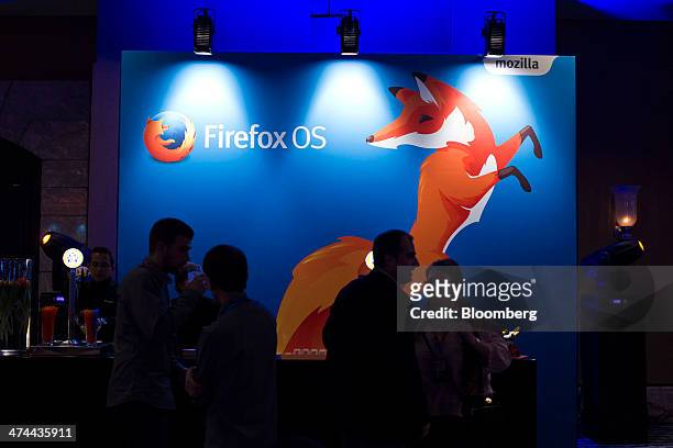 Attendees pass a Firefox operating system logo during a Mozilla Corp. News conference ahead of the Mobile World Congress in Barcelona, Spain, on...