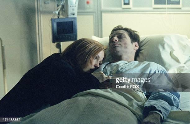 Agent Dana Scully at the bedside of Agent Mulder , who was previously thought dead and is now inexplicably showing signs of life in the "Deadalive"...