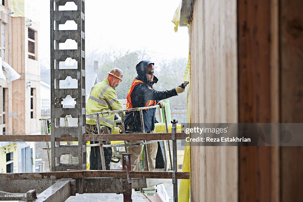 Construction workers install protective membrane