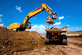 Industrial truck loader excavator moving earth and unloading int