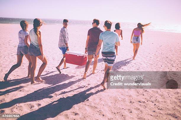 freunde am strand tragen cooler box für eine party - coffee break party stock-fotos und bilder