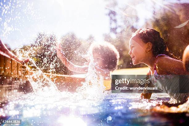 little afro menina e amigos chapinhar na piscina juntos - splash pool imagens e fotografias de stock