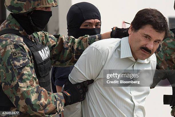 Drug trafficker Joaquin "El Chapo" Guzman is escorted to a helicopter by Mexican security forces at Mexico's International Airport in Mexico city,...