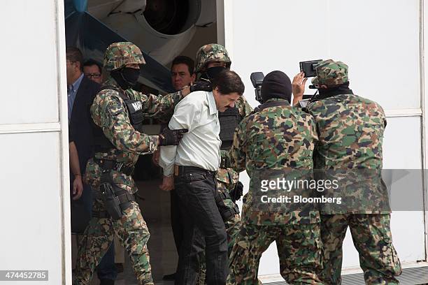 Drug trafficker Joaquin "El Chapo" Guzman is escorted to a helicopter by Mexican security forces at Mexico's International Airport in Mexico city,...